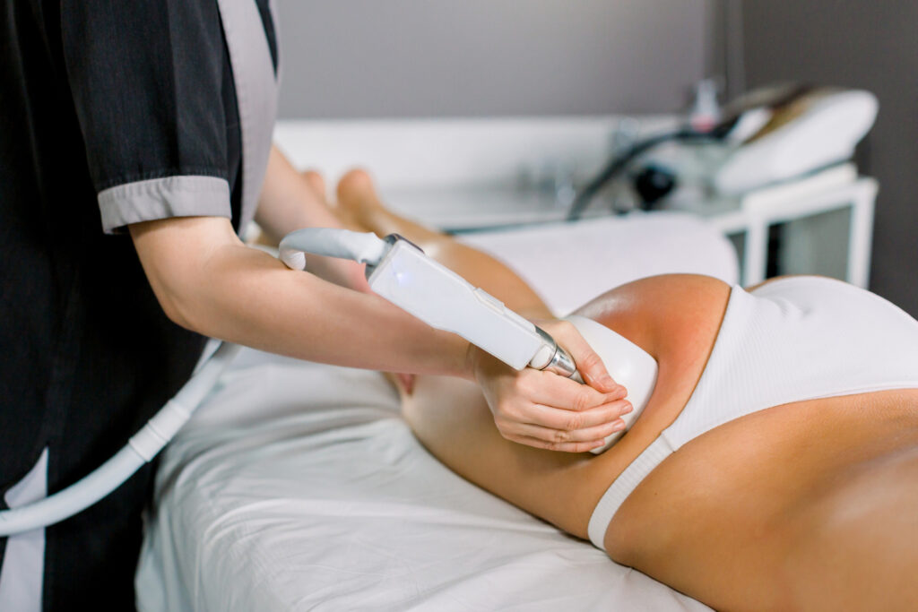 Female doctor with client in a body contouring treatment on hips