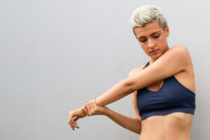 Young woman looking at her arms for treating keratosis