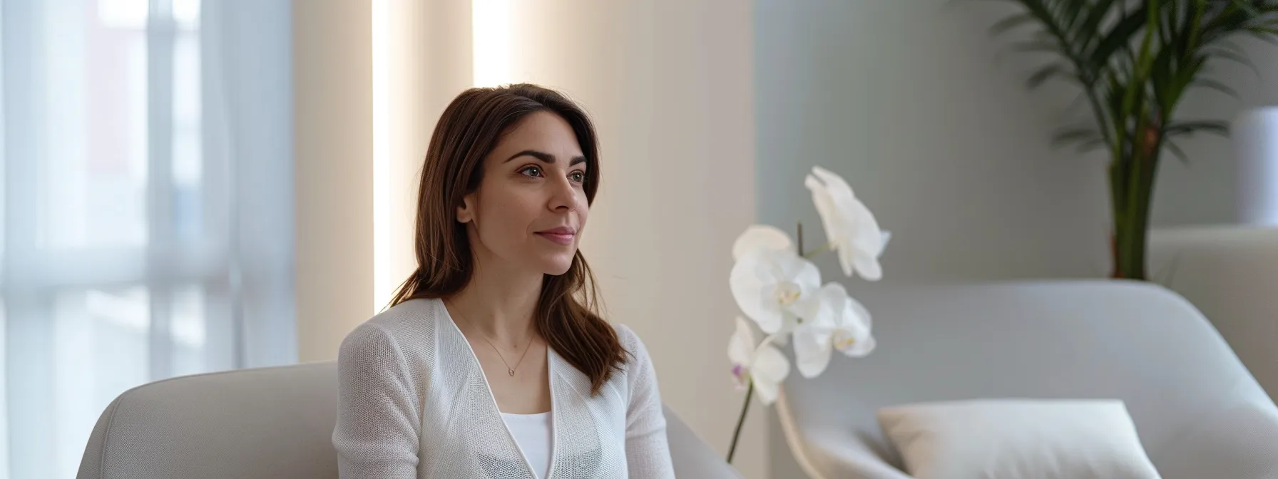 a woman sitting comfortably in a modern consultation room at lemel medical spa, discussing personalized pre-treatment recommendations for laser hair removal, with a serene and focused expression.